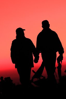 A couple enjoying sunset at the Bay bridge clipart