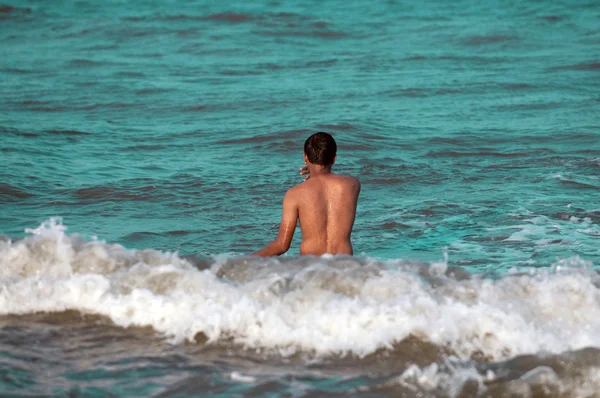 Молодой человек наслаждается волнами на пляже — стоковое фото
