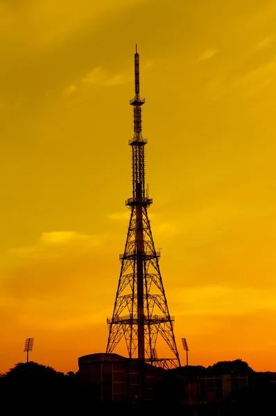 Высокая телекоммуникационная башня во время тропического заката — стоковое фото