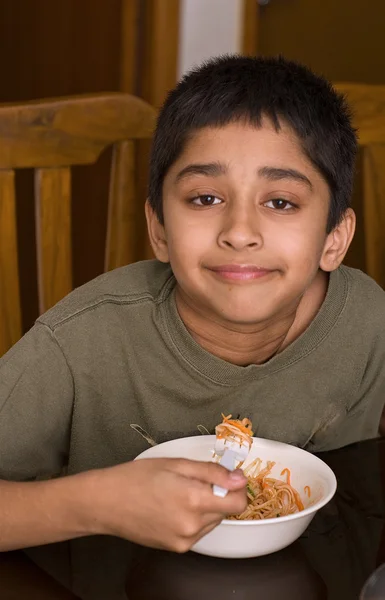 Bonito garoto indiano feliz comer macarrão — Fotografia de Stock