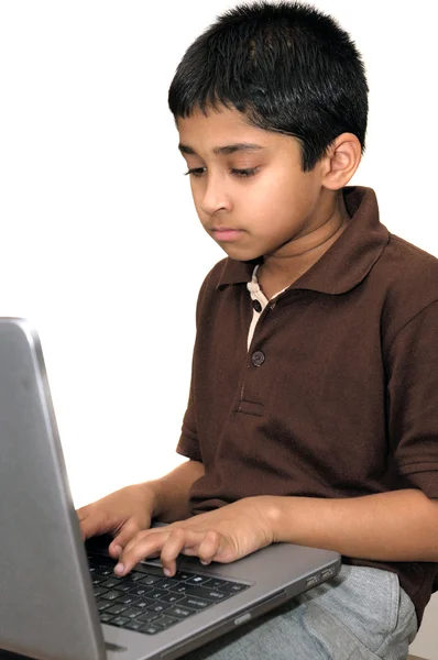 英俊年轻的印度小孩用一台笔记本电脑工作 — 图库照片