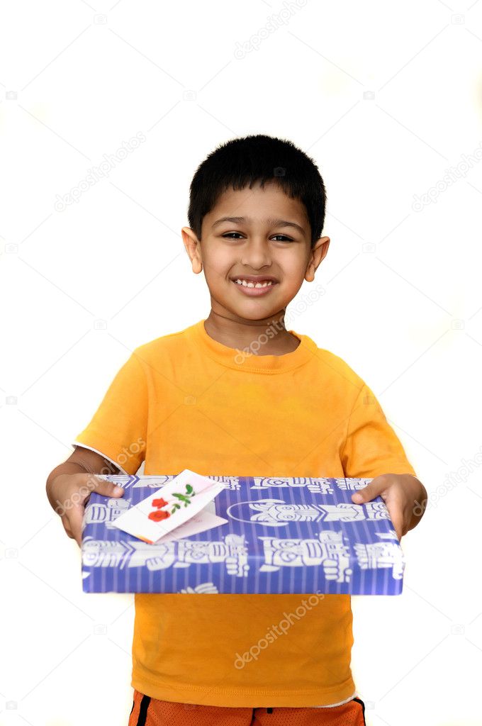 An handsome Indian kid holding a present in his hand
