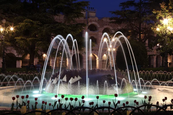 stock image Fountain in front of the ancient roman amphitheatre in Verona, Italy at night