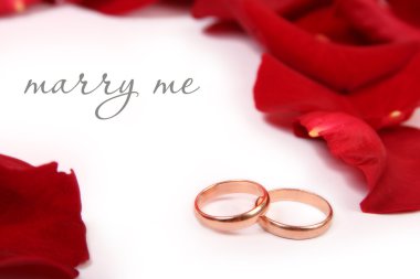 Golden wedding rings on rose's petals clipart