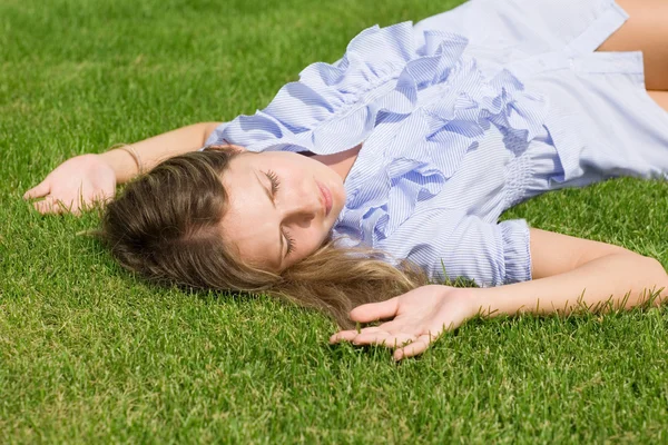Gyönyörű lány feküdt le a fű — Stock Fotó