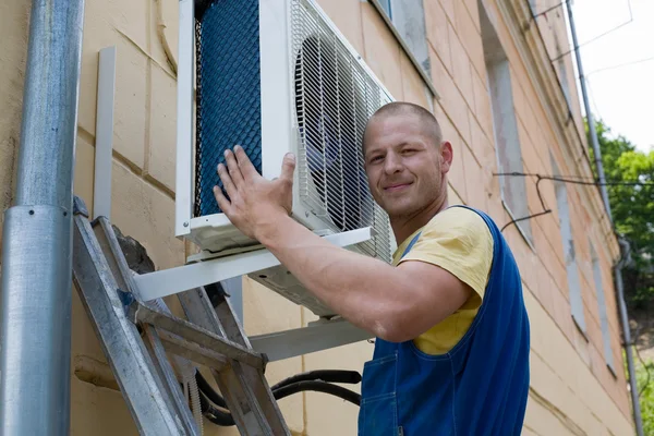 Instalador define um novo ar condicionado — Fotografia de Stock