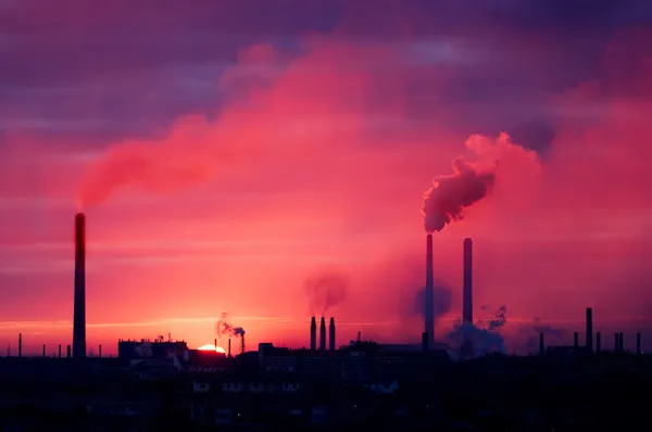 Fabriek silhouet op een rijzende zon — Stockfoto