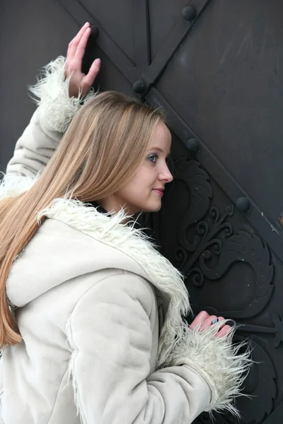 Blond meisje in bont jas glimlachen — Stockfoto