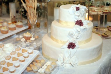 Three tiered wedding cake with white icing clipart