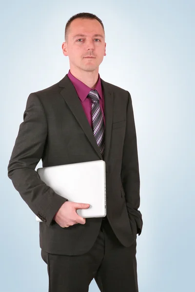 Young businessman holding a laptop — Stock Photo, Image