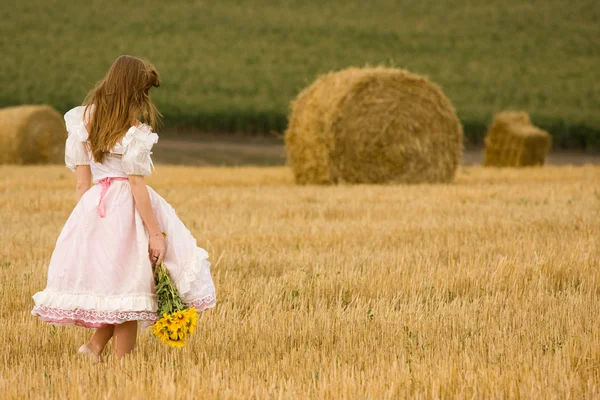 フィールド内の花のドレスを着た女性 — ストック写真