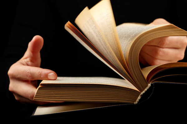 Looking thruogh book with motion blur on black background