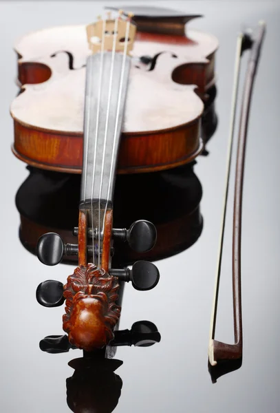 Скрипка и лук на темном фоне — стоковое фото