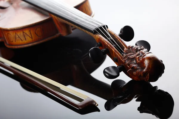 Violino e arco no fundo escuro — Fotografia de Stock