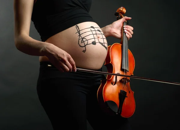 Беременная женщина со скрипкой — стоковое фото