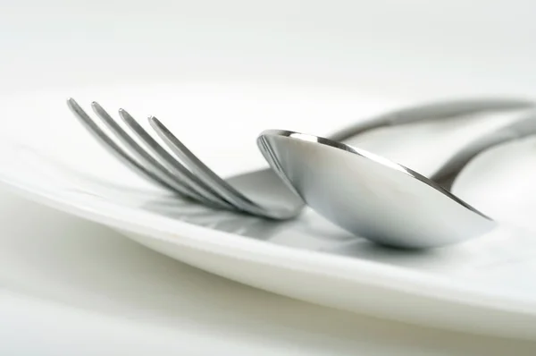 Foto de tenedor y cuchara en el plato — Foto de Stock