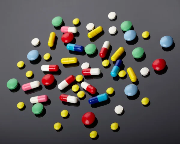 Coloridas píldoras sobre fondo oscuro — Foto de Stock