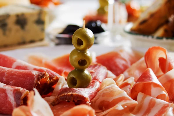 Green olives and cured ham — Stock Photo, Image