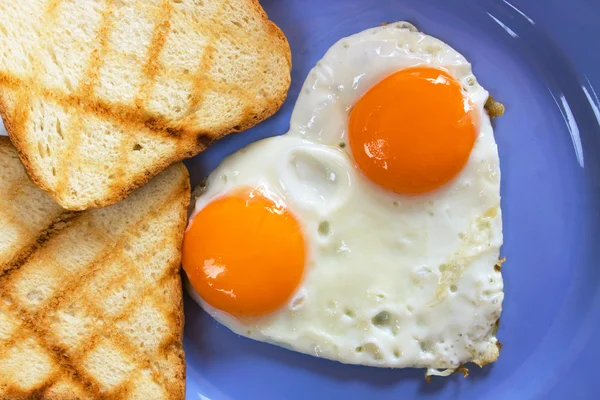 Heart shaped fried eggs — Stock Photo, Image