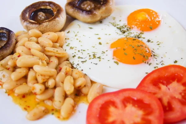 Жареные яйца с бобами и грибами — стоковое фото