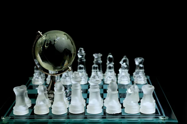 水晶棋子上具有全球忐忑不安的行黑色背景 — 图库照片