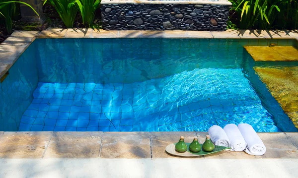 Handdukar och medel för spa lämna på randen till pool — Stockfoto