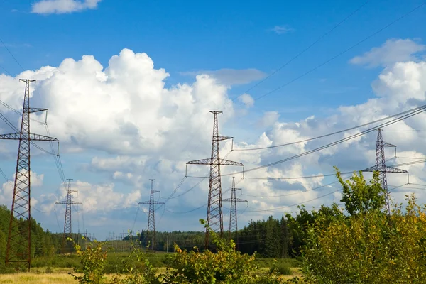 Linia wysokiego napięcia energii elektrycznej transmisji na pole, wśród drewna — Zdjęcie stockowe