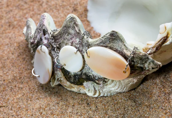 Το κέλυφος εξωτικά θαλάσσια με ένα μαργαριτάρι χάντρες ψέματα στην άμμο — Φωτογραφία Αρχείου