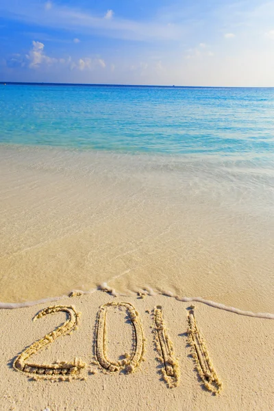 Na písku na okraji oceánu je napsáno "2011" — Stock fotografie