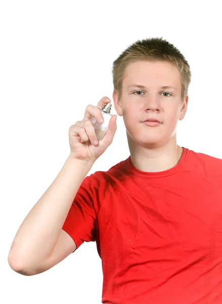 Der Junge, der Teenager, der Parfüm versprüht — Stockfoto