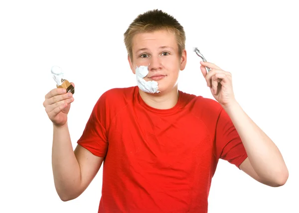 Der Junge, der Teenager versucht zum ersten Mal eine Rasur und ist verwirrt. — Stockfoto