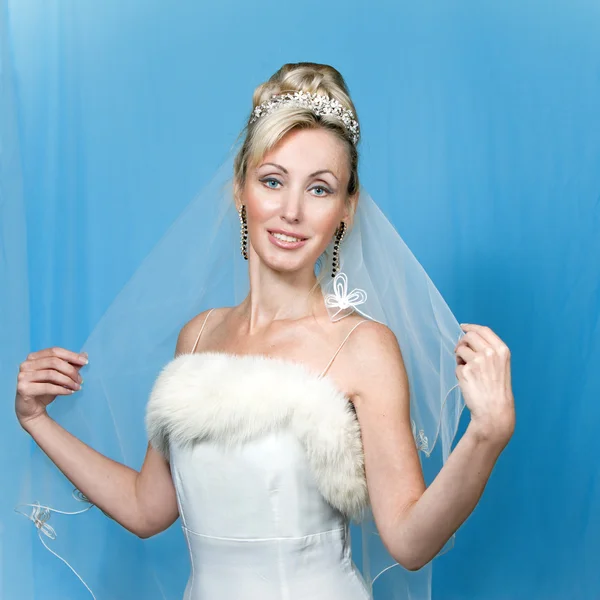 De gelukkige bruid op een blauwe achtergrond — Stockfoto