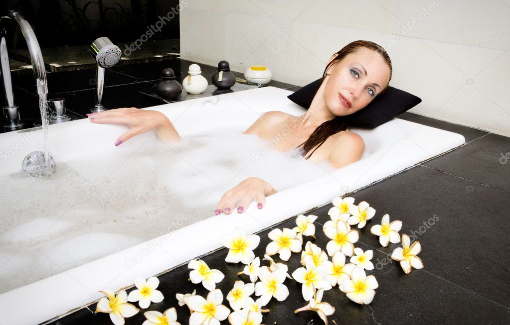 Girl lays in soapsuds in bathing, full water