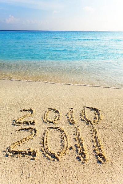 На піску на краю океану написано " 2011 " — стокове фото