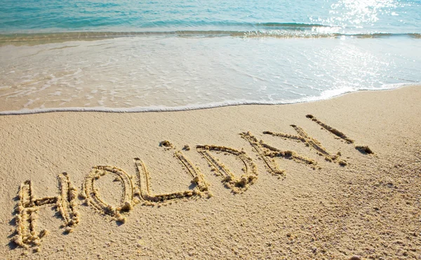 Vakantie - het is geschreven op zand voordat een golf — Stockfoto