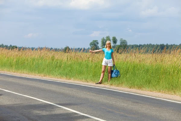 Hitchhiking girl votes on road — Stock Photo, Image