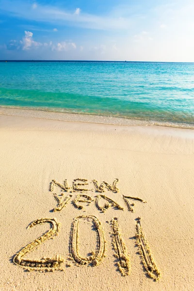 On sand at ocean edge it is written "2011" — Stock Photo, Image