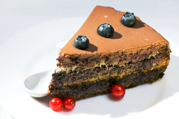 Choklad kaka med röda vinbär och en blackberry — Stockfoto