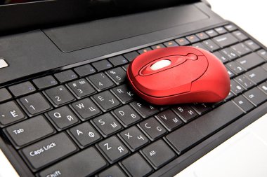 The red computer mouse on the black keyboard clipart