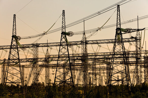 High-voltage line of electricity transmissions on a sunset