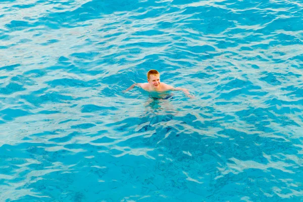 Teenager has a rest on turquoise transparent water of ocean — Stock Photo, Image