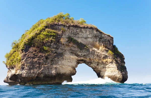 El arco de piedra natural - la roca en el océano. Indonesia, Bali —  Fotos de Stock