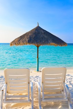 Parasol and chaise lounges, Maldives. clipart