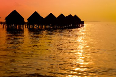 Maldives.Villa kazık zaman batımında suda doğum.