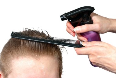 The hairdresser moistens hair to the client before a hairstyle clipart