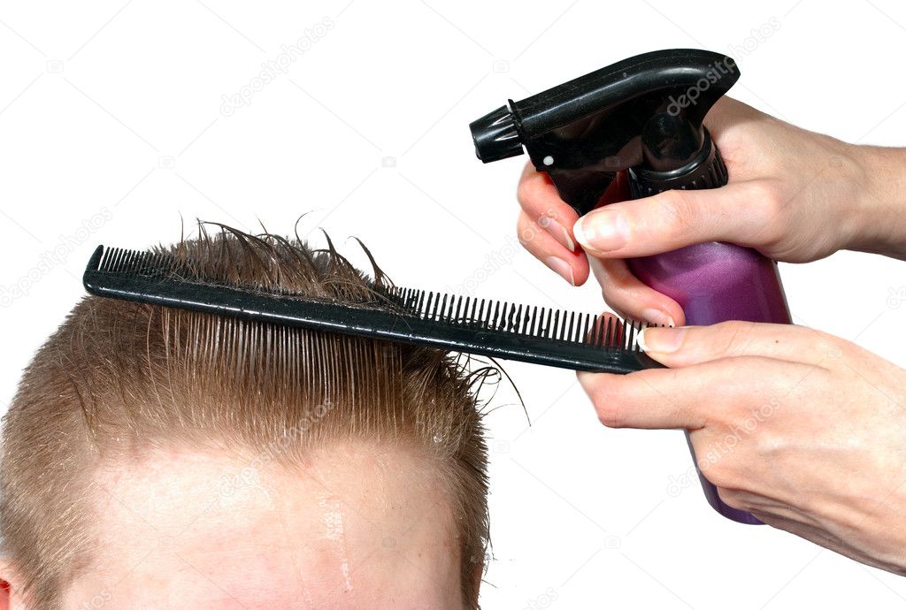 The hairdresser moistens hair to the client before a hairstyle