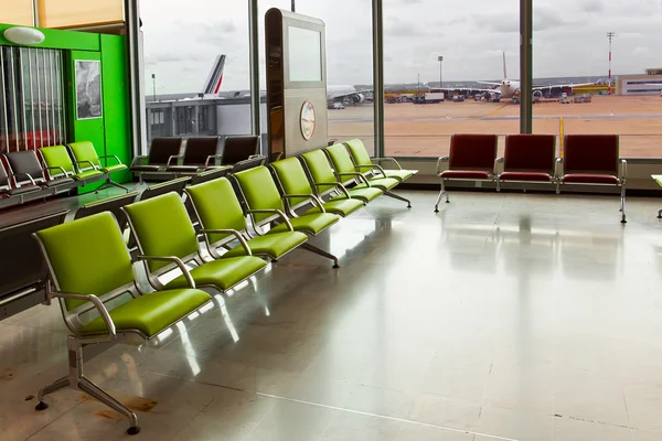 Empty armchairs in hall of expectation of airport and plane behind window — Stock Photo, Image
