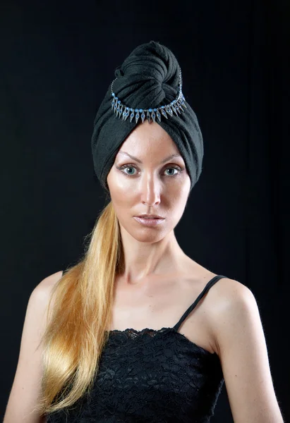 Schöne junge Frau im Ost-Turban auf dunklem Hintergrund — Stockfoto