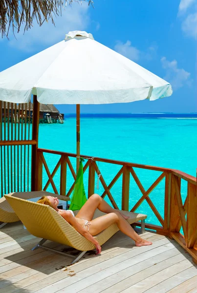 Ung kvinna solbränna på villa på havet Maldiverna — Stockfoto