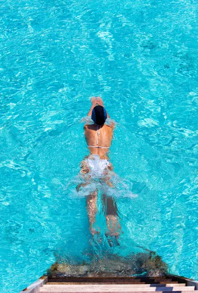 Junge Sportlerin schwimmt von Villa-Treppe auf Wasser. — Stockfoto